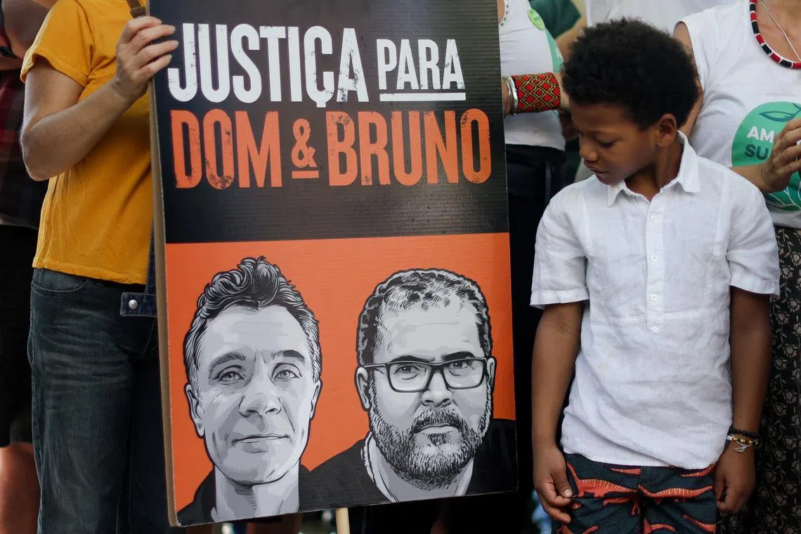FILE PHOTO: A boy looks at a placard during a demonstration one year after Phillips and Brazilian Indigenous issues expert, Bruno Pereira, were killed in the Amazon, in Copacabana beach in Rio de Janeiro, Brazil June 5, 2023. REUTERS/Pilar Olivares/File Photo