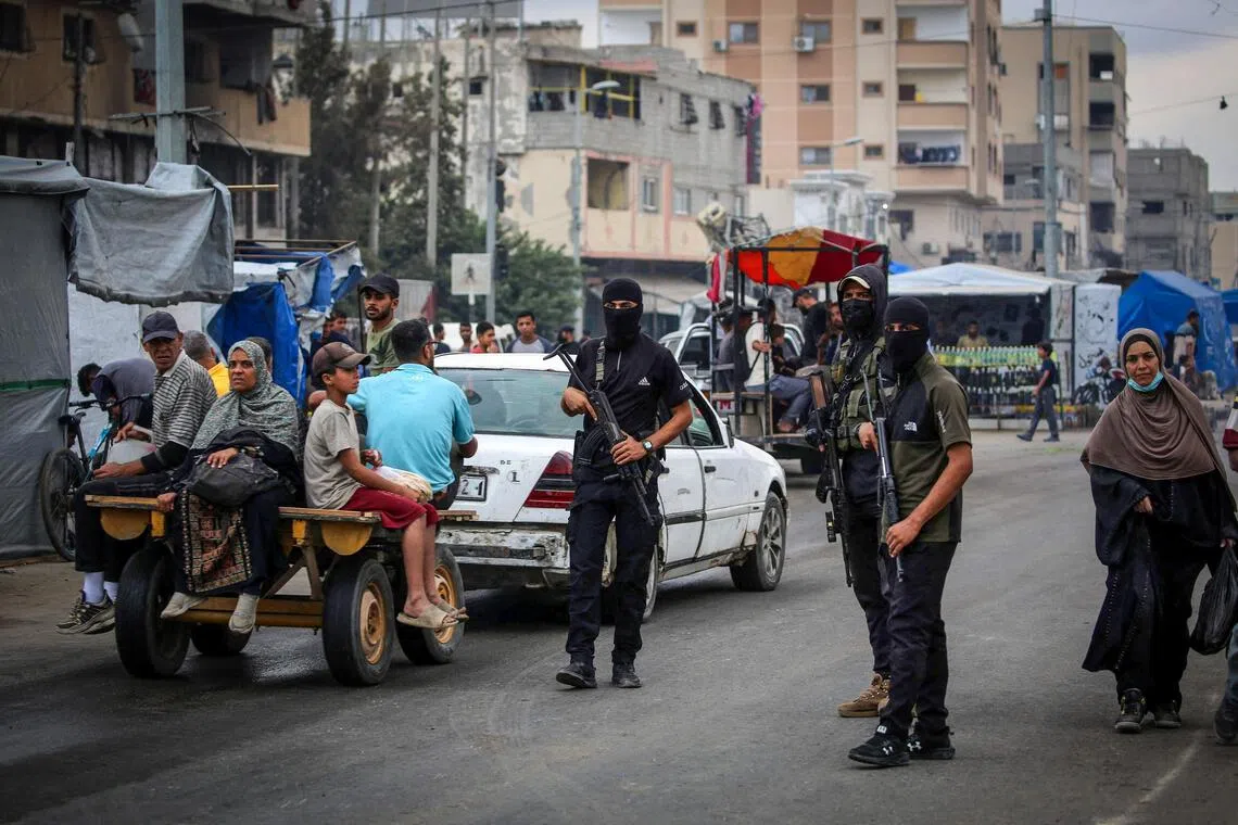 Members of the internal security forces loyal to the Palestinian group Hamas are deployed in the Nuseirat refugee camp in the central Gaza Strip, as displaced people return to Gaza City, on October 12, 2025. Israel declared a ceasefire in Gaza and began to pull back its forces on October 10, as tens of thousands of exhausted Palestinians made their way back to their devastated homes. (Photo by Eyad BABA / AFP)