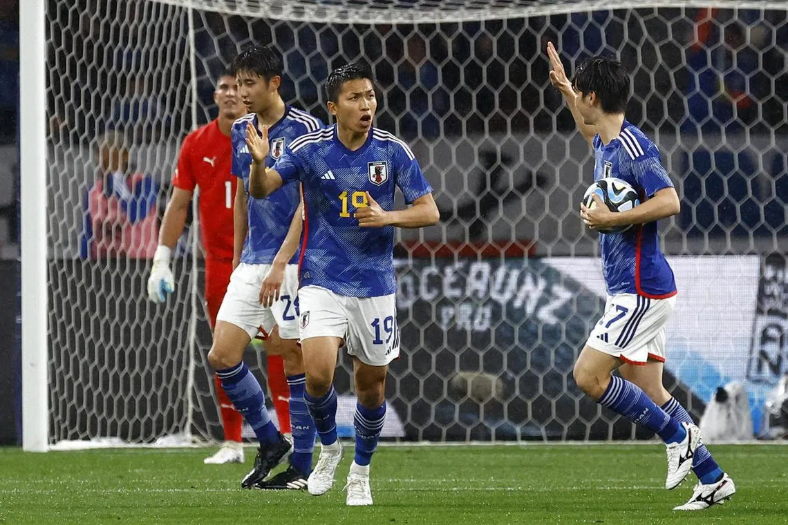 Takuma Nishimura celebrating with his Japan teammates after scoring the equaliser in the 1-1 friendly draw against Uruguay in Tokyo.