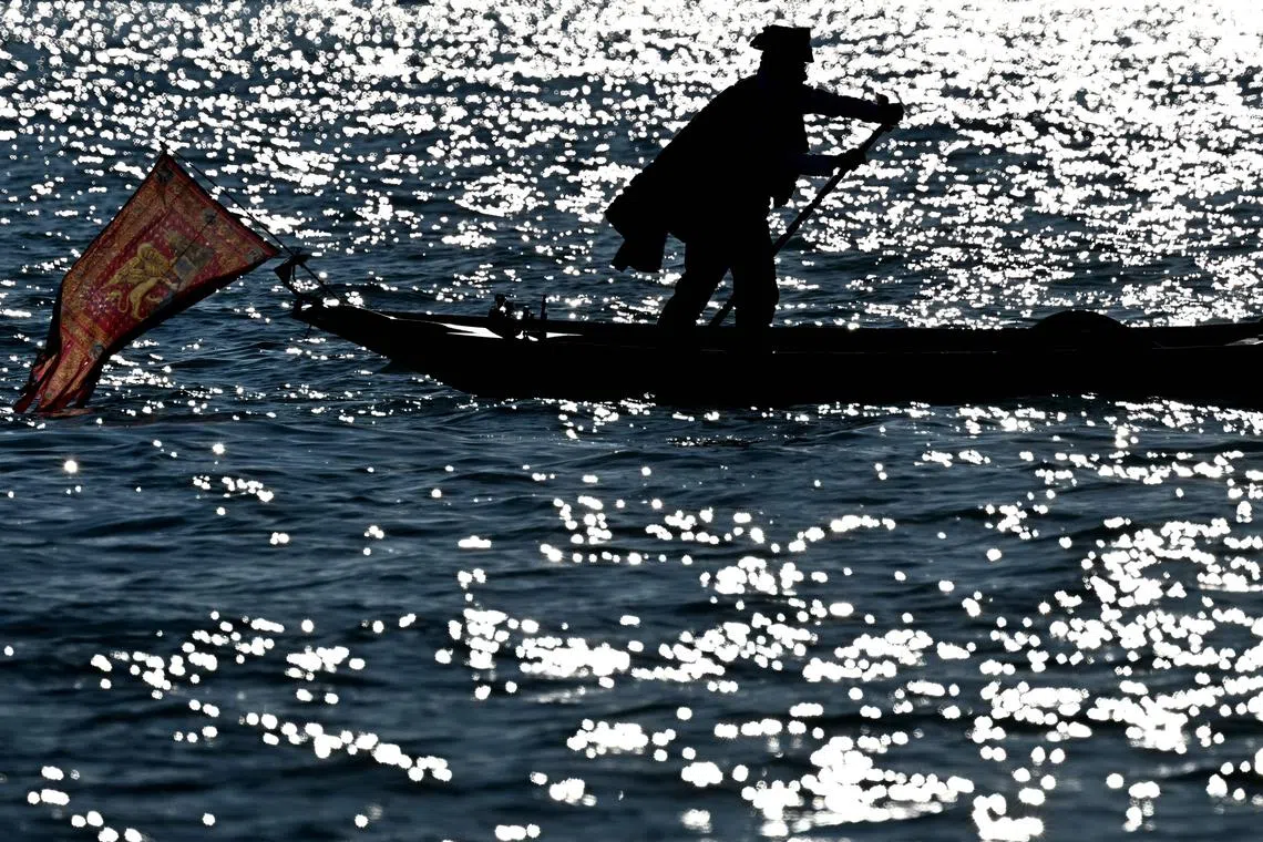 A dressed up reveller sailing on the Grand Canal during the traditional parade of the Coordination of Venetian Rowing Associations, as part of the Venice carnival on Jan 28, 2024. 