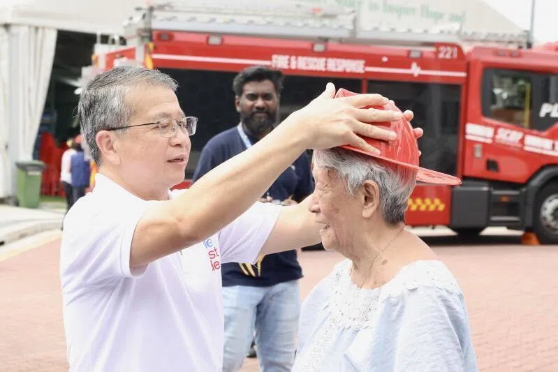 Law Minister and Second Minister for Home Affairs Edwin Tong engages with residents and leading family members on fighting fire at Hands-on Firefighting Station.