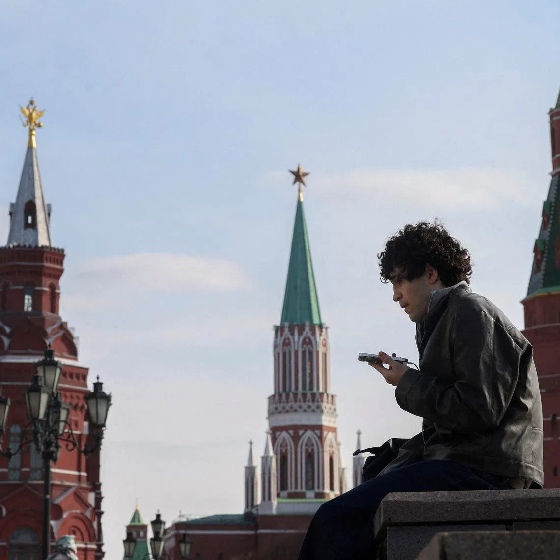 FILE PHOTO: A man checks his mobile phone in central Moscow, Russia, March 17, 2026. REUTERS/Ramil Sitdikov/File Photo