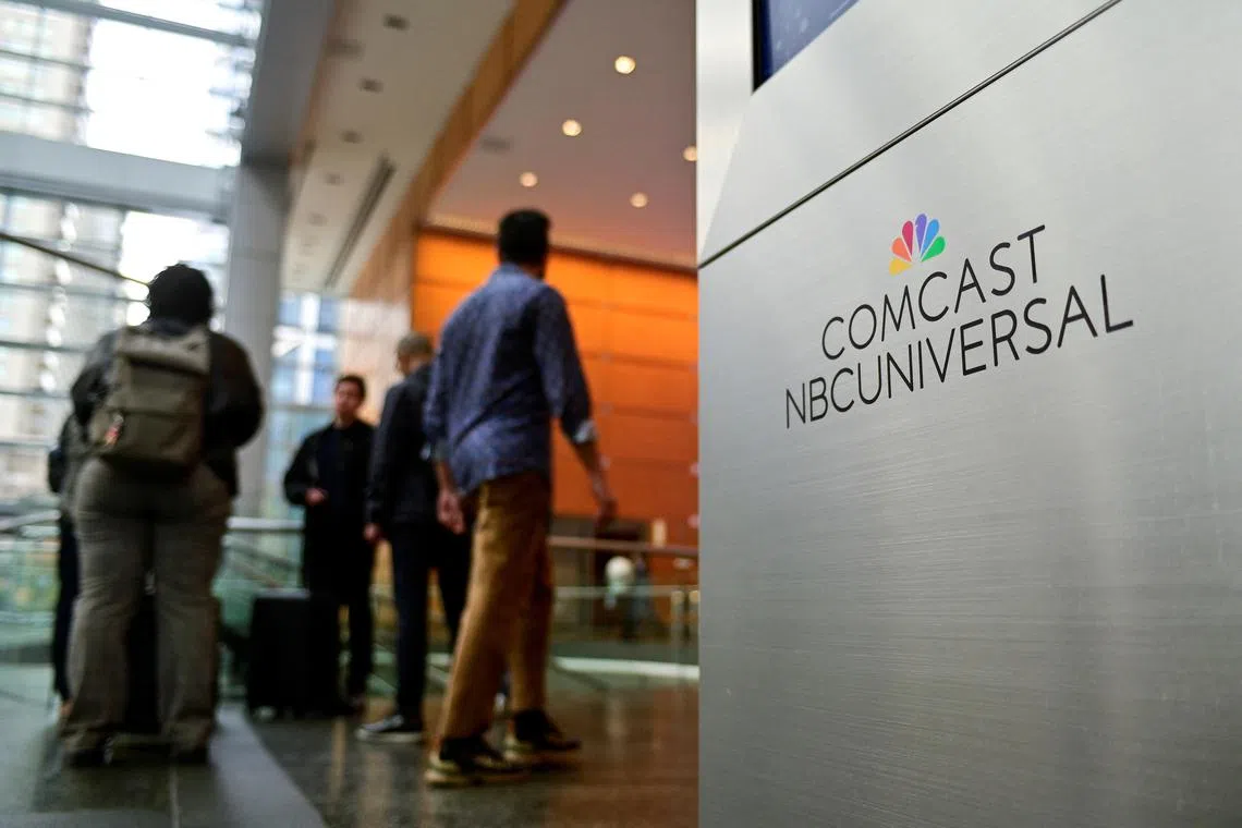 FILE PHOTO: People stand near a signage of Comcast and NBC Universal in the lobby of the corporate headquarters of Comcast, in Philadelphia, Pennsylvania, U.S. November 20, 2024. REUTERS/Bastiaan Slabbers/File Photo