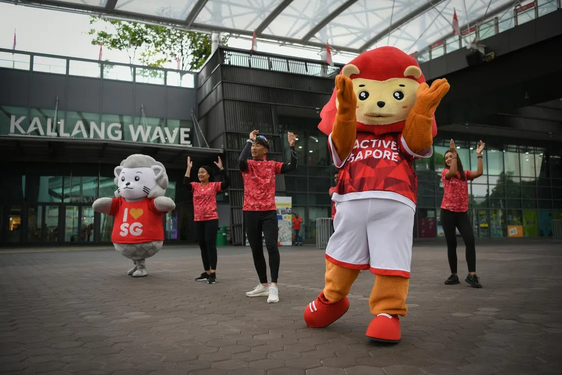 A dance demonstration showing NDP mascot August (in gray) and Sport Singapore lion mascot Nila mascot (in orange), together with Team Nila volunteers.