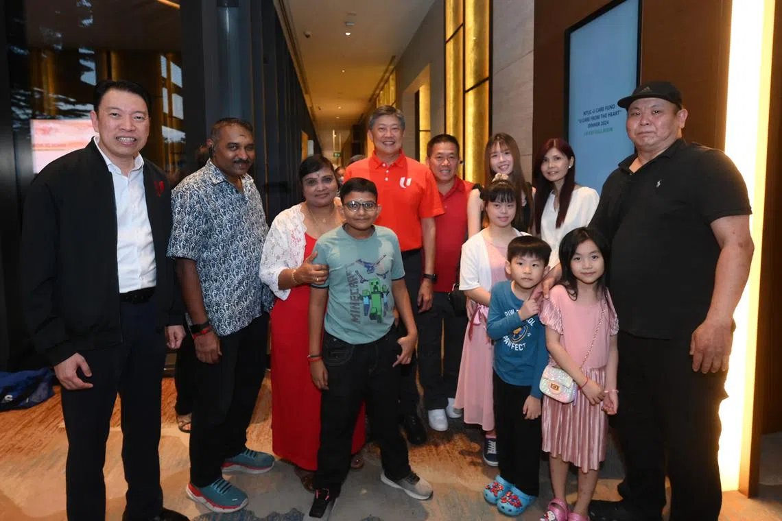 NTUC secretary-general Ng Chee Meng (fifth from left) and NTUC assistant secretary-general Melvin Yong (left) with beneficiaries.