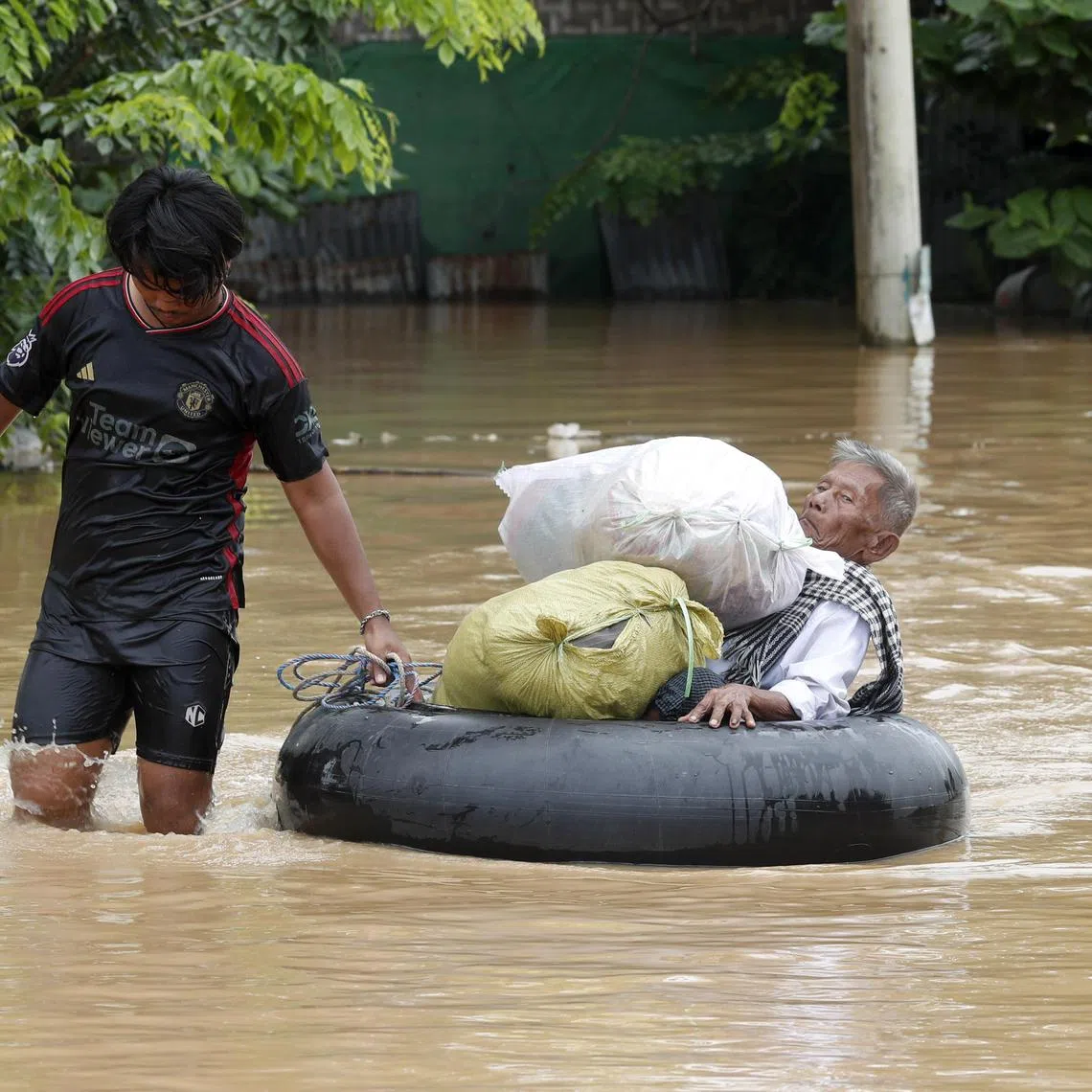 epa11603203 A man carries an elderly man on a tyre tube during the flood in Taungoo, Bago division, Myanmar, 14 September 2024. Heavy rains triggered by Typhoon Yagi have caused severe flooding in parts of Myanmar, leaving thousands stranded in their homes, with further heavy rainfall and thunderstorms expected, according to the state weather office. A statement from the Military announced 59,413 households were affected in 34 townships and set up 187 relief camps for the 236,649 people. There were 33 casualties due to the flood in the country including the Naypyitaw.  EPA-EFE/NYEIN CHAN NAING