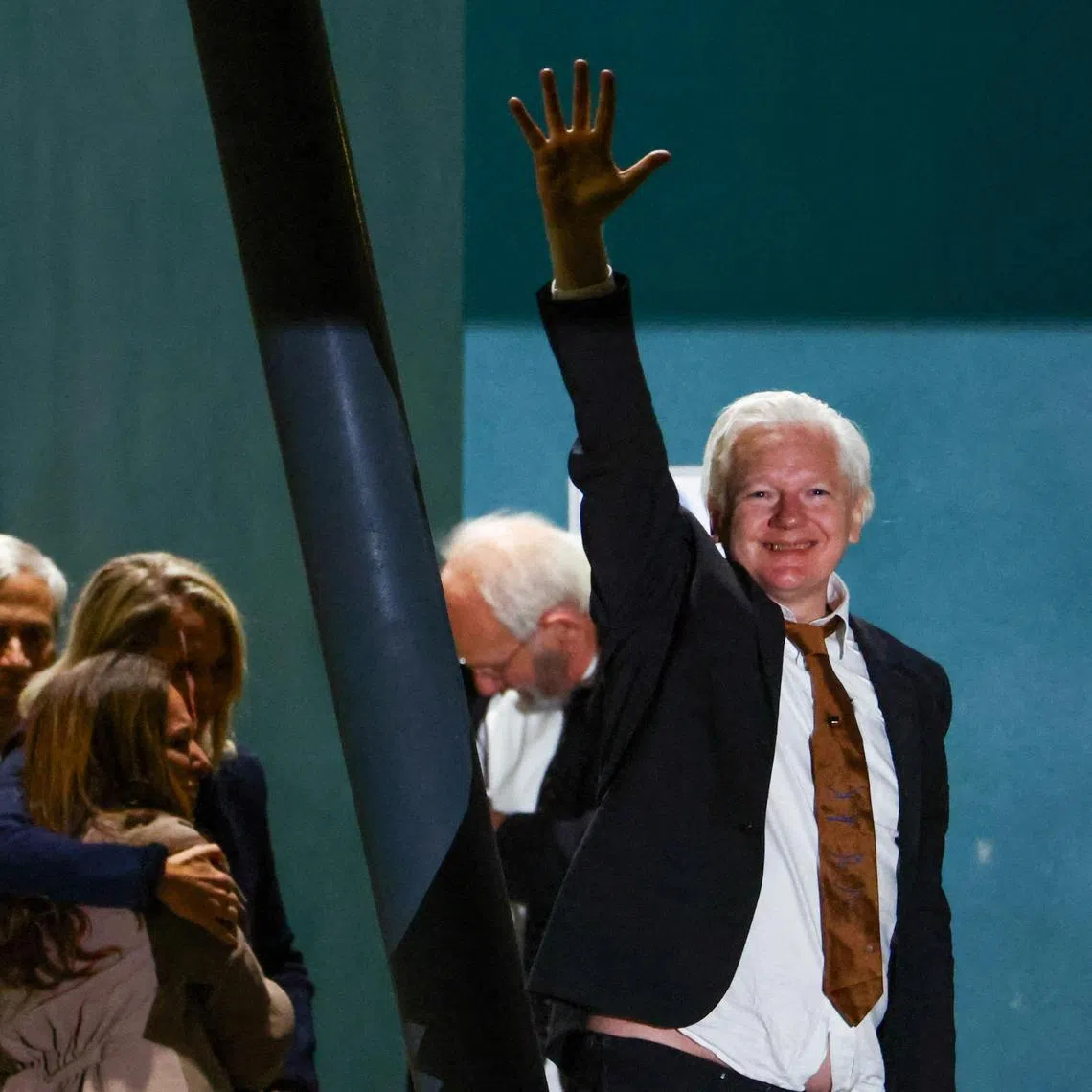 WikiLeaks founder Julian Assange waves as he arrives in Canberra, Australia.