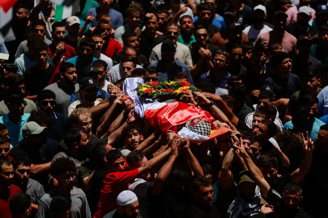 People carry the body of Sayfollah Kamel Musallet, a Palestinian-American man who was beaten to death by settlers, according to the Palestinian Health Ministry, during his funeral near Ramallah, in the Israel-occupied West Bank July 13, 2025. REUTERS/Ammar Awad