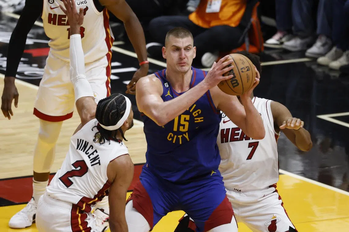 Denver Nuggets centre Nikola Jokic looks to pass as Miami Heat guards Gabe Vincent and Kyle Lowry defends against him in Game 3 of the NBA Finals.