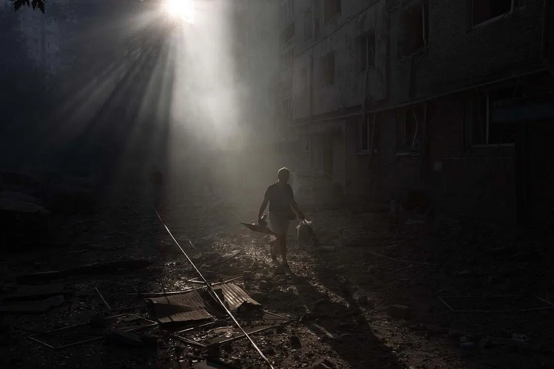TOPSHOT - A person walks next a residential building damaged following a Russian air attack on the Ukrainian capital of Kyiv on July 2, 2026, amid the Russian invasion in Ukraine. Russian missile and drone strikes rocked Kyiv early on July 2, killing at least eight people and wounding dozens, after President Volodymyr Zelensky warned that Moscow was preparing a "massive attack". (Photo by Roman PILIPEY / AFP)