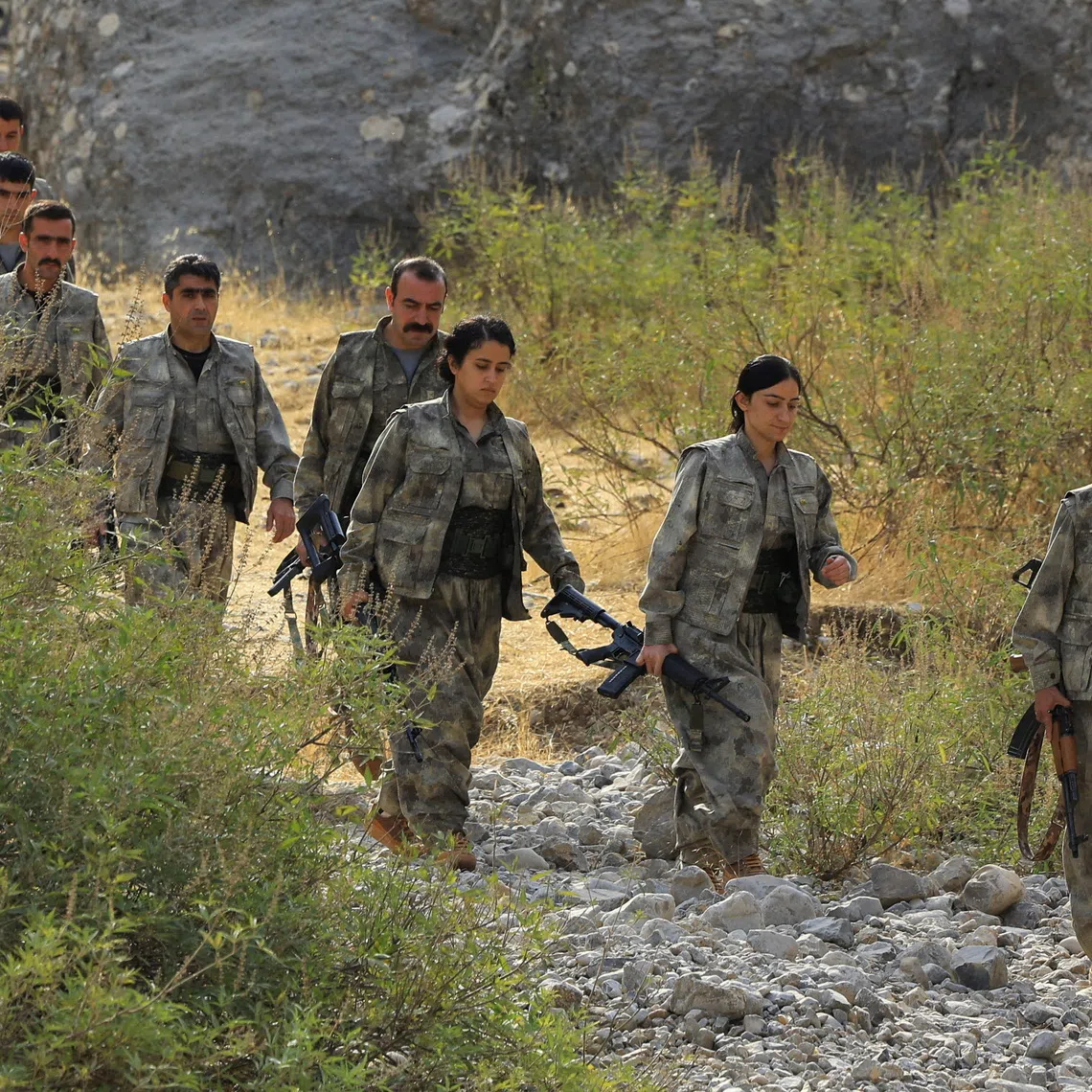 Fighters with the Kurdistan Workers' Party (PKK) walk for a disarmament ceremony marking a significant step toward ending the decades-long conflict between Turkey and the outlawed group, in the Qandil mountains, Iraq October 26, 2025. REUTERS/Thaier Al-Sudani