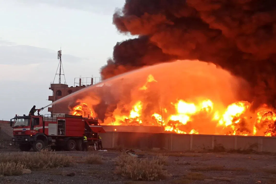 Firefighters attempt to extinguish fires at a power plant following Israeli airstrikes on Hodeidah, Yemen, on Sept 29.