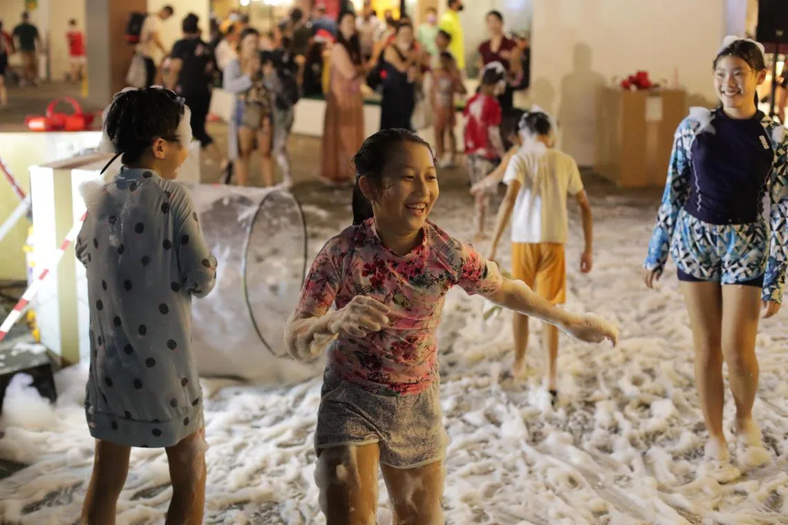 Children enjoying the snow show put up by Tanglin Mall as part of their Christmas celebrations on Dec 7, 2022.