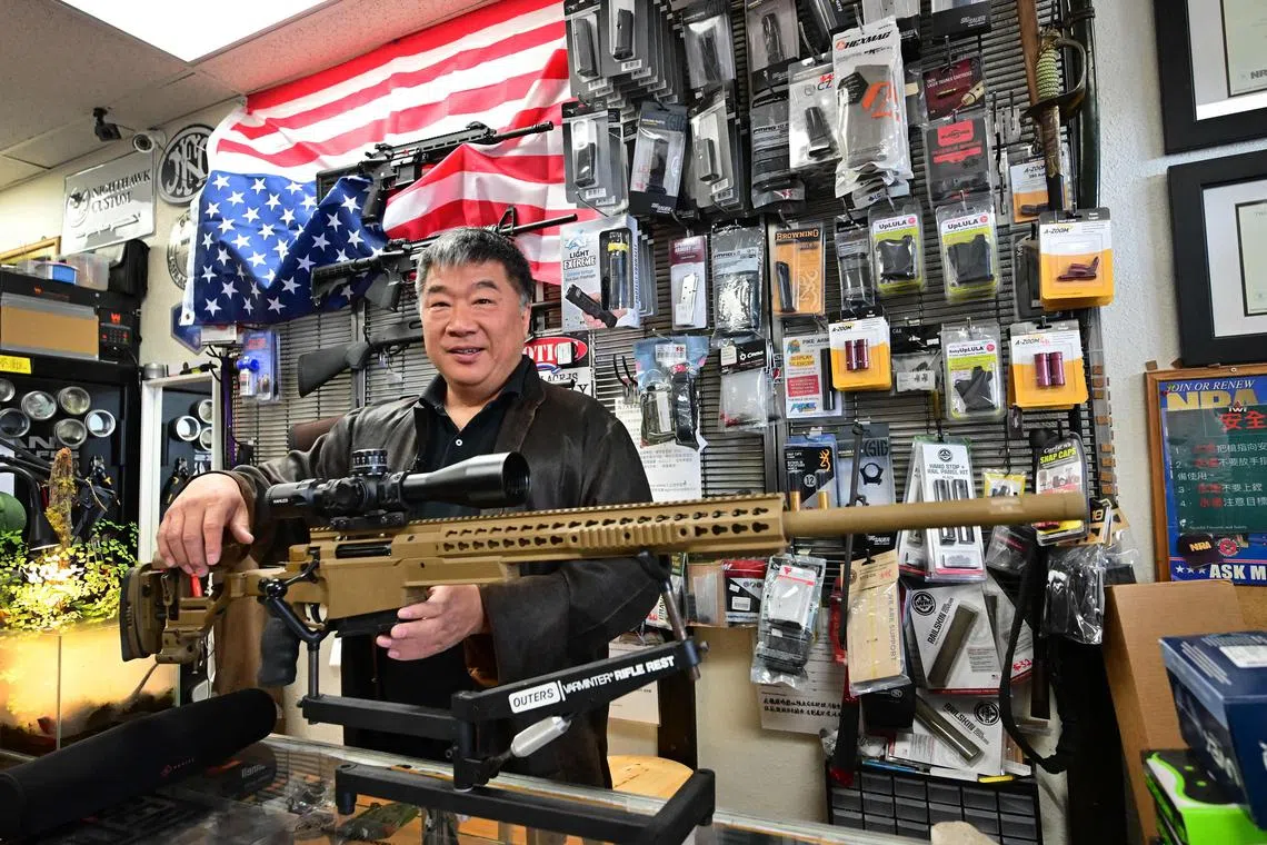 Gun shop owner David Liu holds a British-manufactured Accuracy International sniper rifle at his store in Arcadia, California.