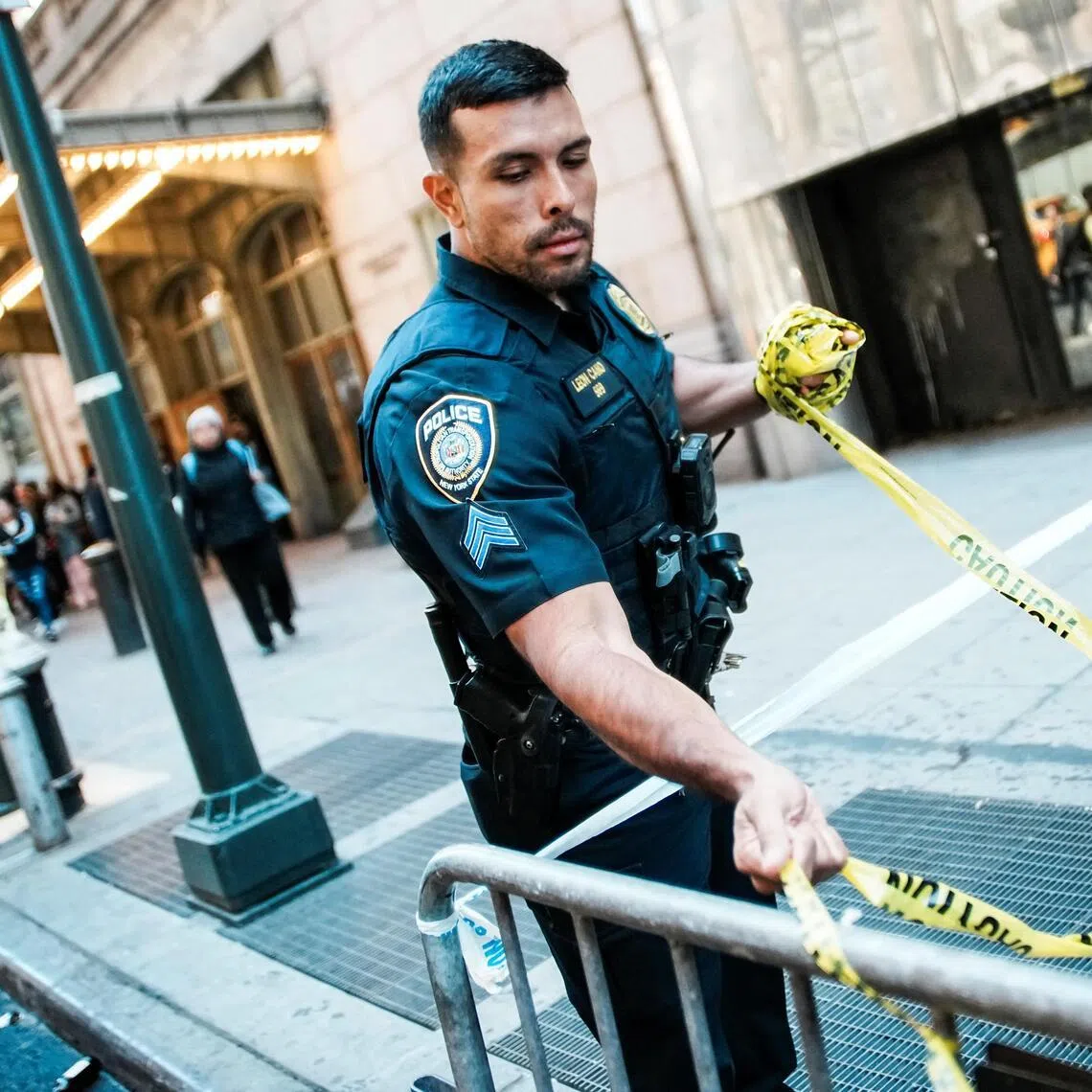 A police officer removing crime scene tape near the entrance to the subway system at Grand Central Station in New York City on April 11, after it was closed due to a machete attack.
