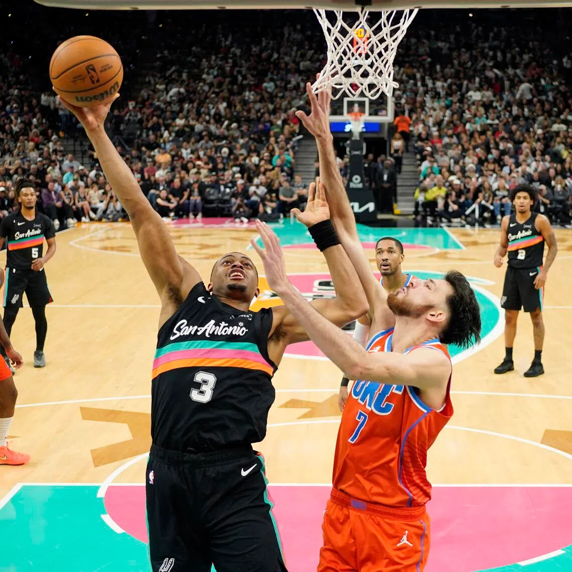 San Antonio Spurs forward Keldon Johnson drives to the basket against Oklahoma City Thunder center Chet Holmgren during the second half at Frost Bank Center.