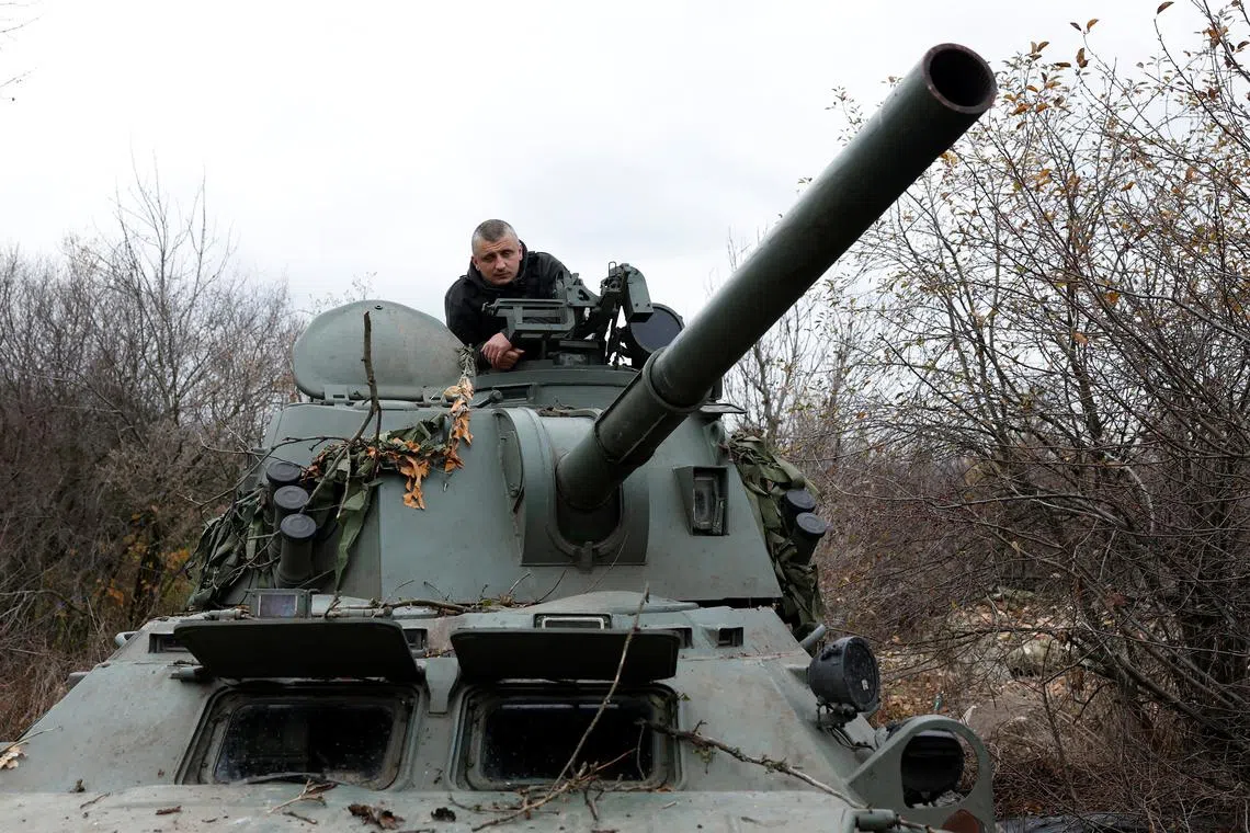 Ukrainian soldiers prepare to fire a mortar round from a tank captured from Russian soldiers, at a battle in Husarivka, Ukraine, in March 2022.