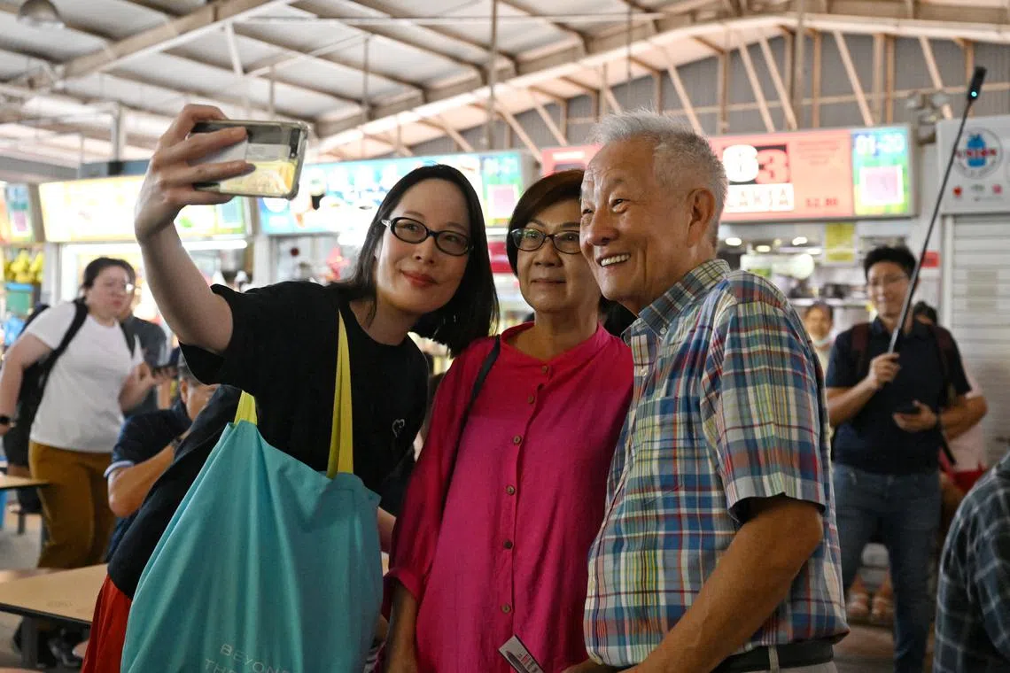 Mr Ng Kok Song and his fiancee Sybil Lau (left) with members of the public at the Ghim Moh Market and Food Centre on Aug 24.