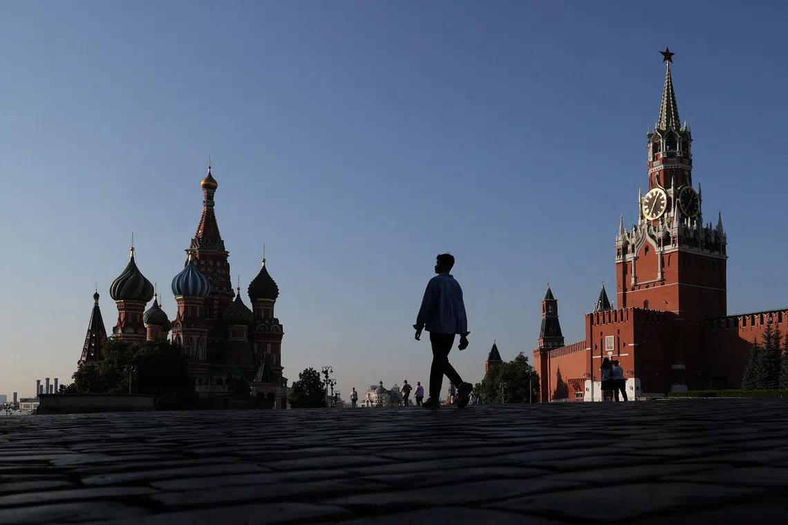 FILE PHOTO: People walk in front of St. Basil's Cathedral and Spasskaya Tower in Red Square in Moscow, Russia July 25, 2025. REUTERS/Anton Vaganov/ File Photo