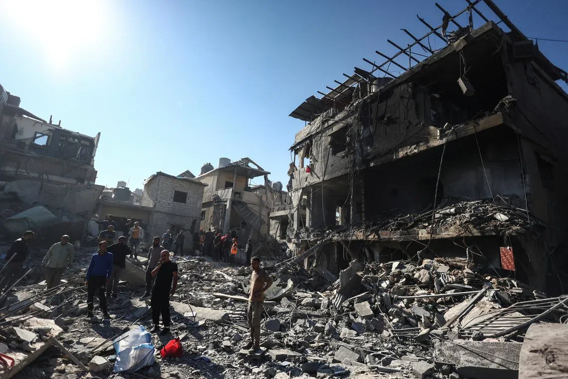 People stand on the rubble of a demolished building after an Israeli strike near the Rafik Hariri University Hospital, amid ongoing hostilities between Hezbollah and Israeli forces, in Beirut, Lebanon October 22, 2024. REUTERS/Yara Nardi
