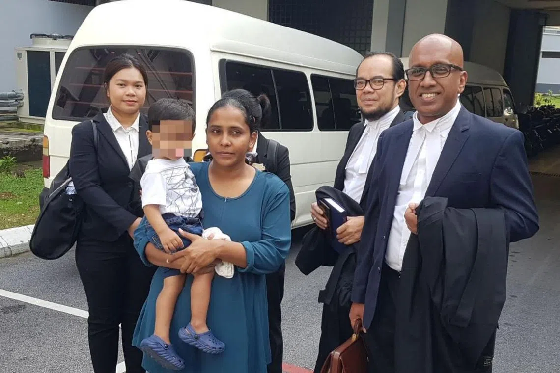 R. Devaki, who can be seen carrying her son, with her lawyers (from right) Haresh Mahadevan and Ramzani Idris outside the court.