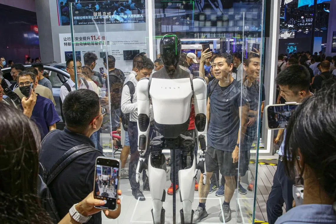 Visitors look at the second generation of Tesla's humanoid robot Optimus in Shanghai on July 5, 2024.