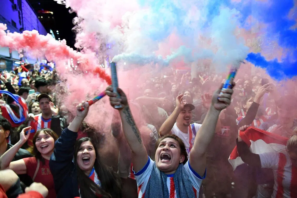 Paraguayan fans celebrating during a live  telecast of the 2026 FIFA World Cup football match between Germany and Paraguay in Asuncion.