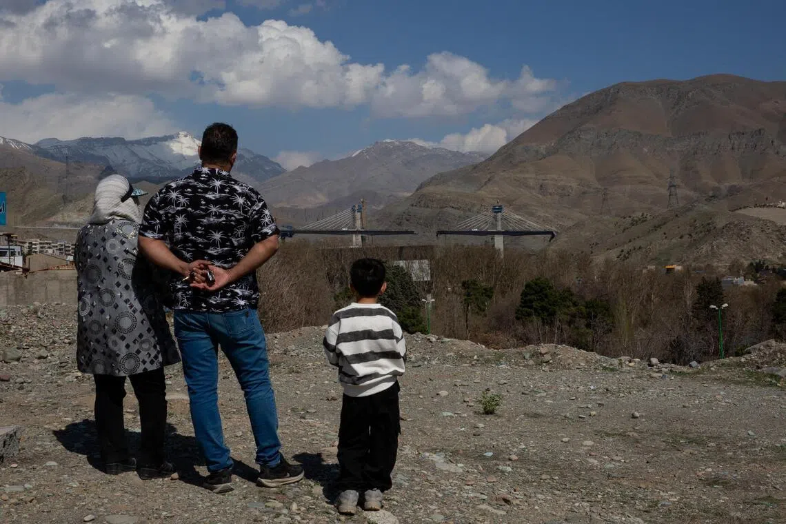 People look at a highway bridge near Tehran, Iran, that was damaged in a US strike that President Donald Trump celebrated on April 3, 2026.