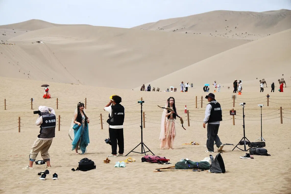 The desert dunes of Dunhuang have become photo hot spots for dolled-up tourists.