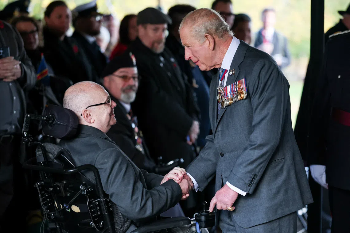 Britain’s King Charles greets a veteran during the LGBTQ+ Armed Forces Dedication ceremony at the National Memorial Arboretum in Alrewas, Staffordshire, Britain, on Oct 27.