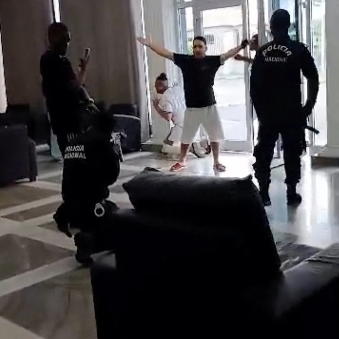 A police officer points a firearm at a migrant deported by the United States to Equatorial Guinea at Hotel Bamy in Malabo, Equatorial Guinea, September 5, 2026, in this screengrab from video. Video obtained by REUTERS/Handout