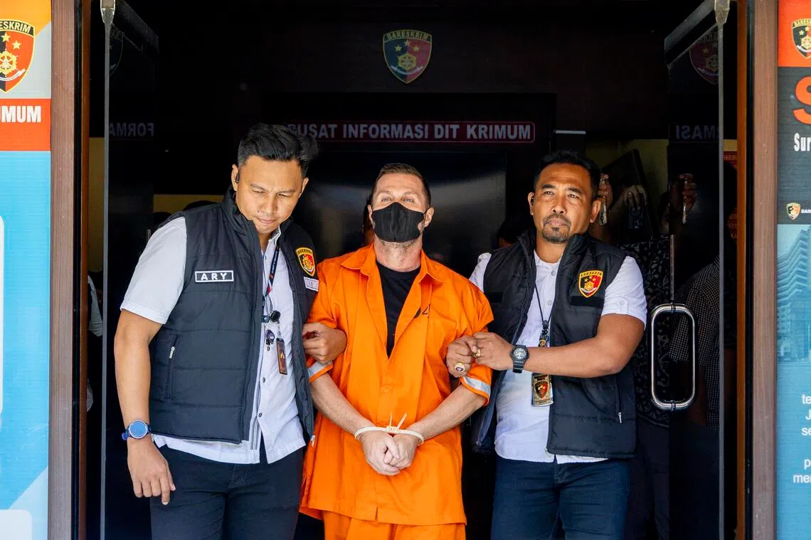 Scottish national Steven Lyons is escorted by police officers at the Bali Police headquarters in Denpasar, Bali, Indonesia, on March 31.