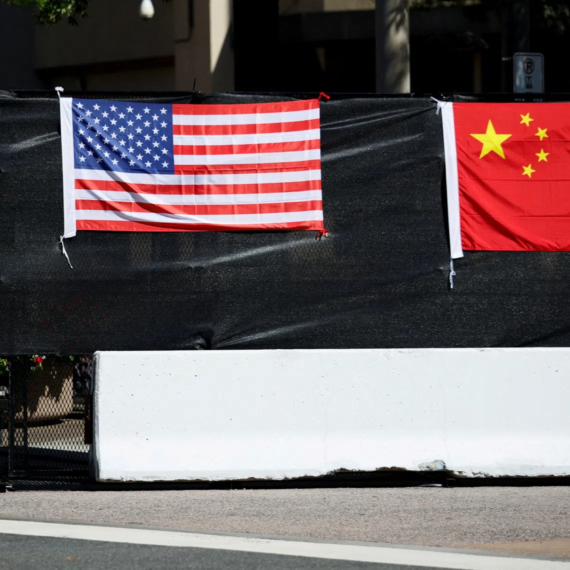 FILE PHOTO: A US flag and a Chinese flag are displayed on a security barrier, on the day of an official visit by Chinese President Xi Jinping and his wife, Peng Liyuan, to the White House in Washington, DC, US, September 25, 2026. REUTERS/Evan Vucci/File Photo