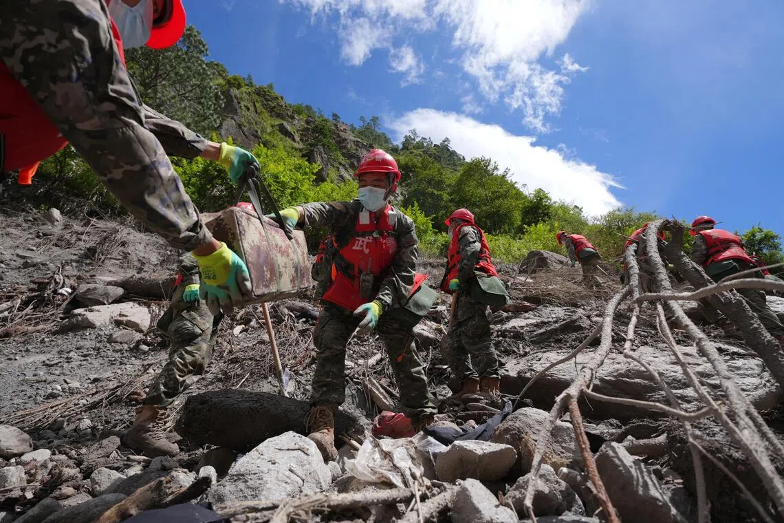 Chinese People’s Armed Police officers clearing debris near Gyirong Port following a mudslide, in Gyirong county on Aug 28.