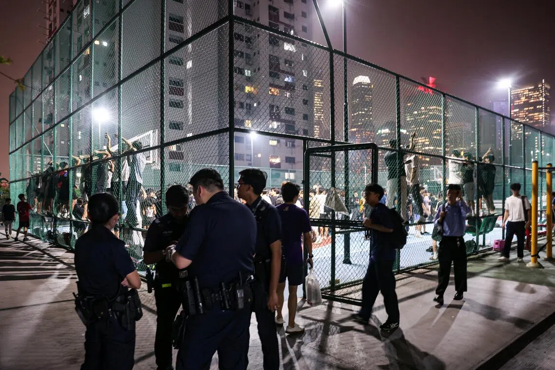 Police officers at Chinatown Complex basketball court as members of the public gathered for a glimpse of basketball influencer Matt Kiatipis on Oct 6, 2026. ST PHOTO: BRIAN TEO