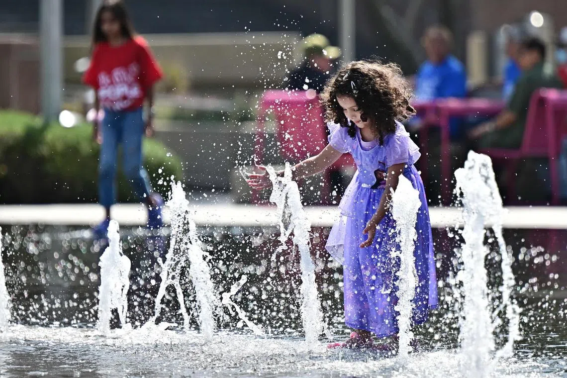A child plays in the water fountain at Grand Park in Los Angeles, California.