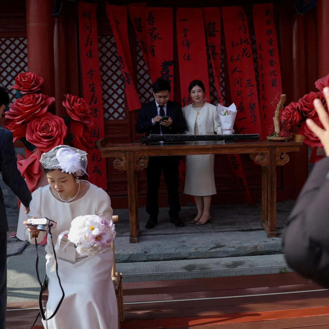FILE PHOTO: Newlywed couples pose for pictures at the Huguo Guanyin Temple, an outdoor marriage registration site in Beijing, China, October 28, 2025. REUTERS/Tingshu Wang/File Photo