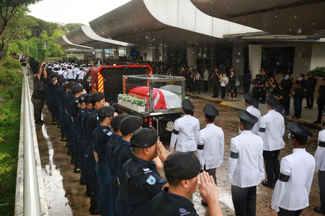 SCDF personnel saluting the hearse headed for Service Hall 1 during a ceremonial procession for Sergeant (1) Edward H Go at Mandai Crematorium and Columbarium on Dec 13, 2022. ST Photo: Kevin Lim dsfire13