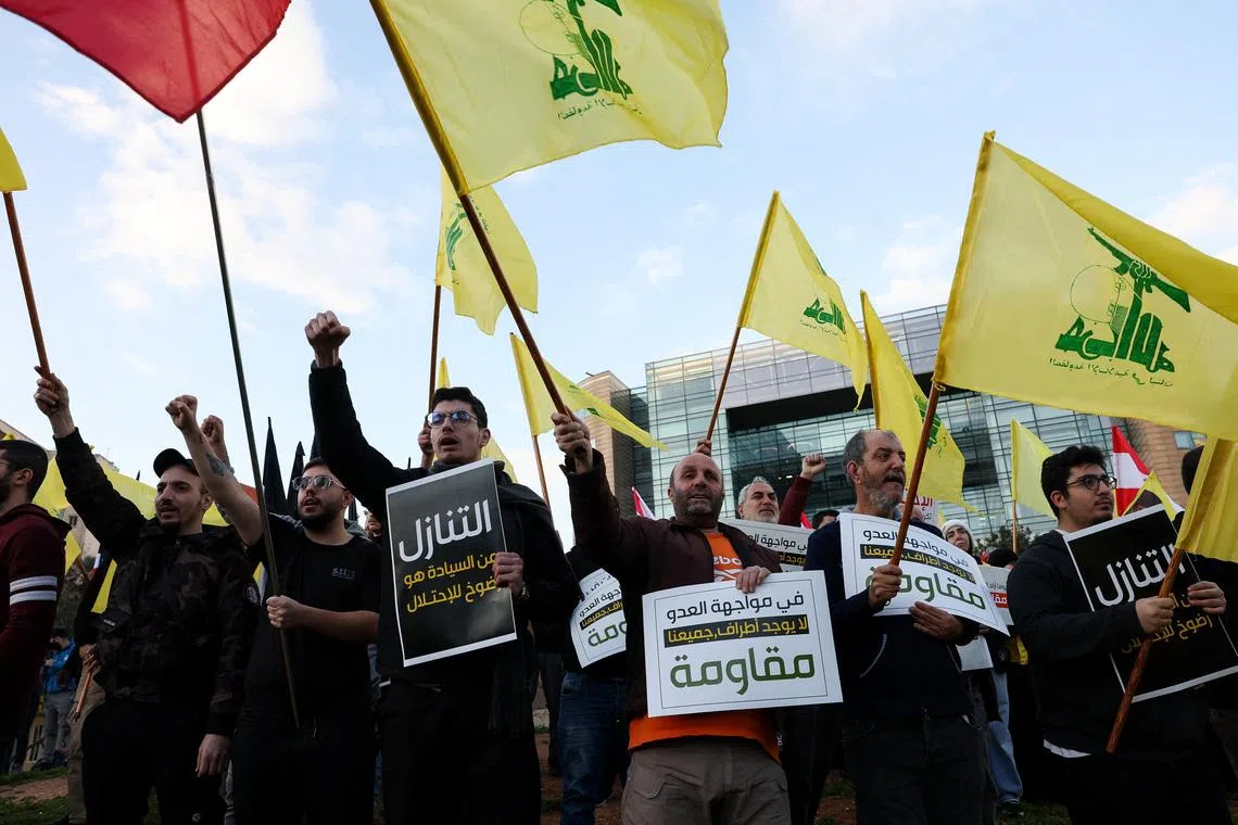 Protesters hold placards and Hezbollah flags during a demonstration condemning recent Israeli military actions in Lebanon, in Beirut, Lebanon February 4, 2026. REUTERS/Mohamed Azakir