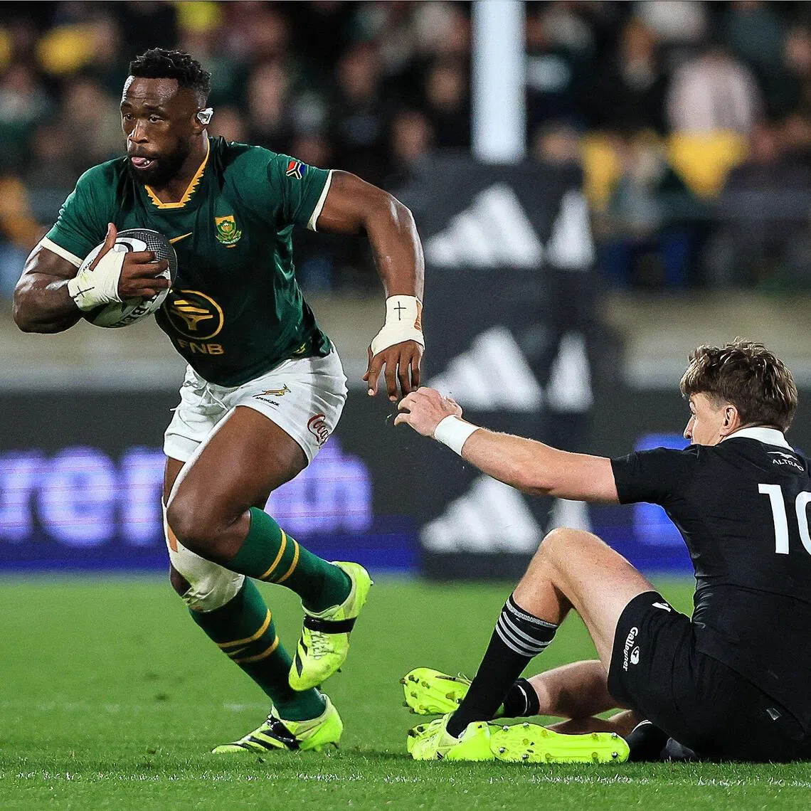 South Africa’s Siya Kolisi (L) runs the ball during the Rugby Championship Test match between New Zealand’s All Blacks and South Africa’s Springboks at Sky Stadium in Wellington on September 13, 2025. (Photo by Grant Down / AFP)