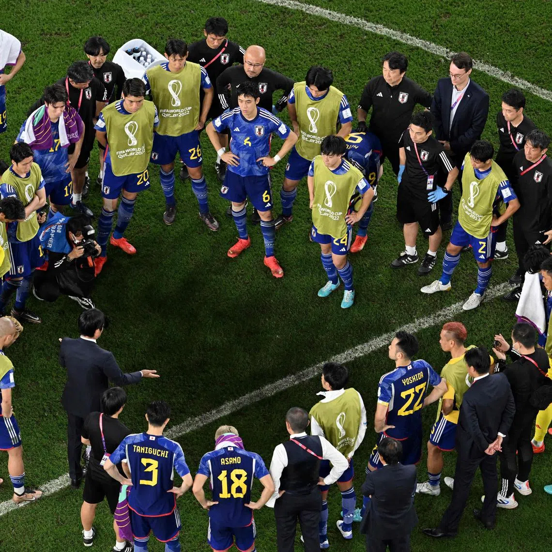 Japan's coach Hajime Moriyasu (Left, bottom) talks to the players after losing in the penalty shoot-out after extra time at the Qatar 2022 World Cup round of 16 football match between Japan and Croatia.