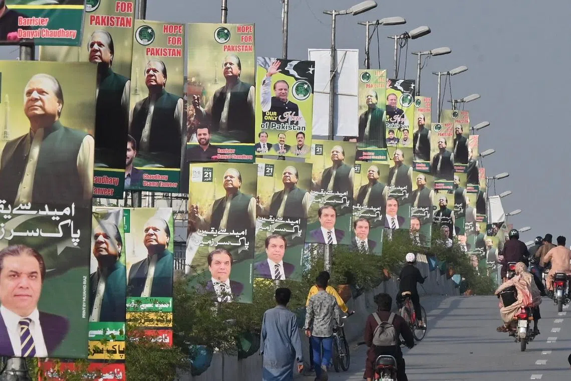Commuters ride past the welcoming posters of Nawaz Sharif, on his return home on Saturday.