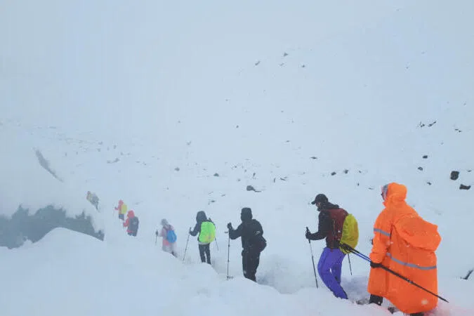 A screengrab from video shows trekkers leaving their campsite, as unusually heavy snow and rainfall pummeled the Himalayas, in the Tibet Region, China, Oct 5.