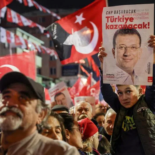 A supporter of Turkey's main opposition Republican People's Party (CHP) holds a poster with a picture of jailed Istanbul Mayor Ekrem Imamoglu during a rally in Istanbul, Turkey, on Nov 12, 2025.