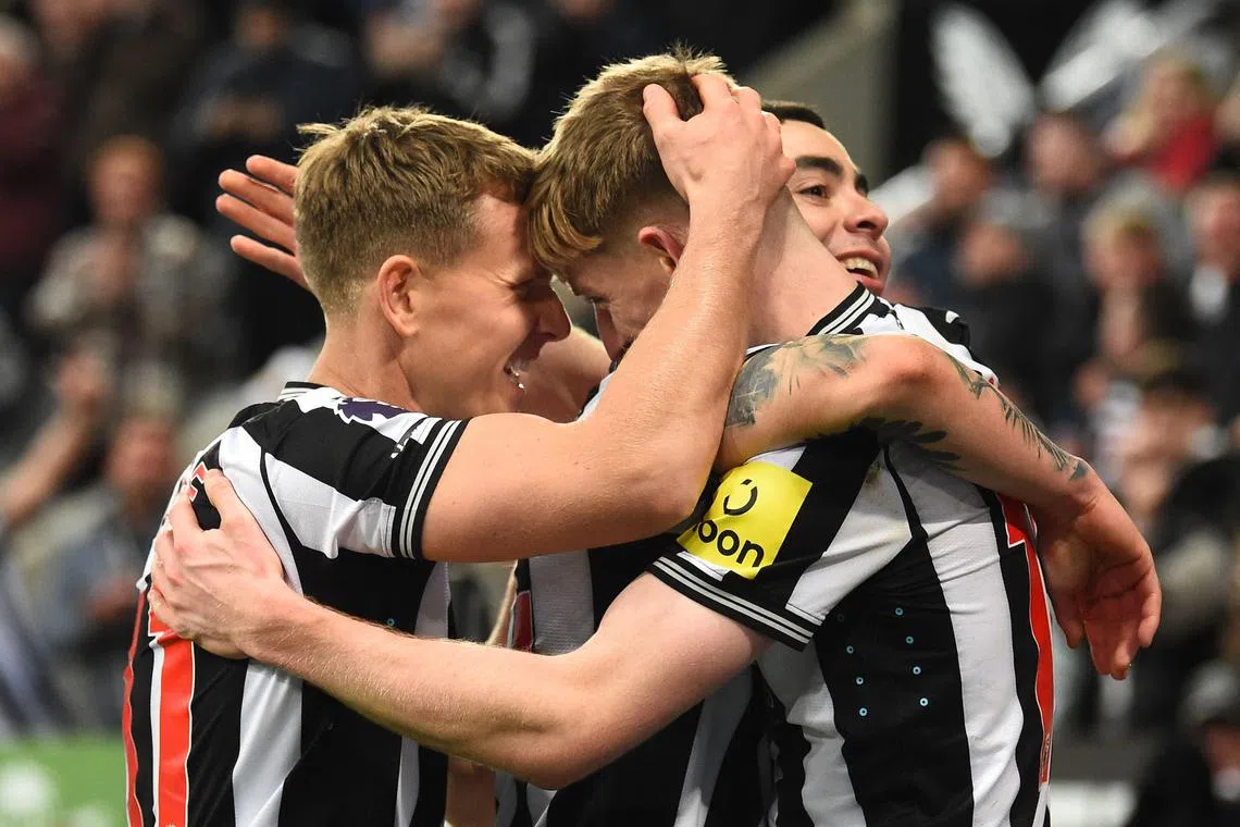 Newcastle United's Anthony Gordon is mobbed by teammates after scoring the team's fourth goal.