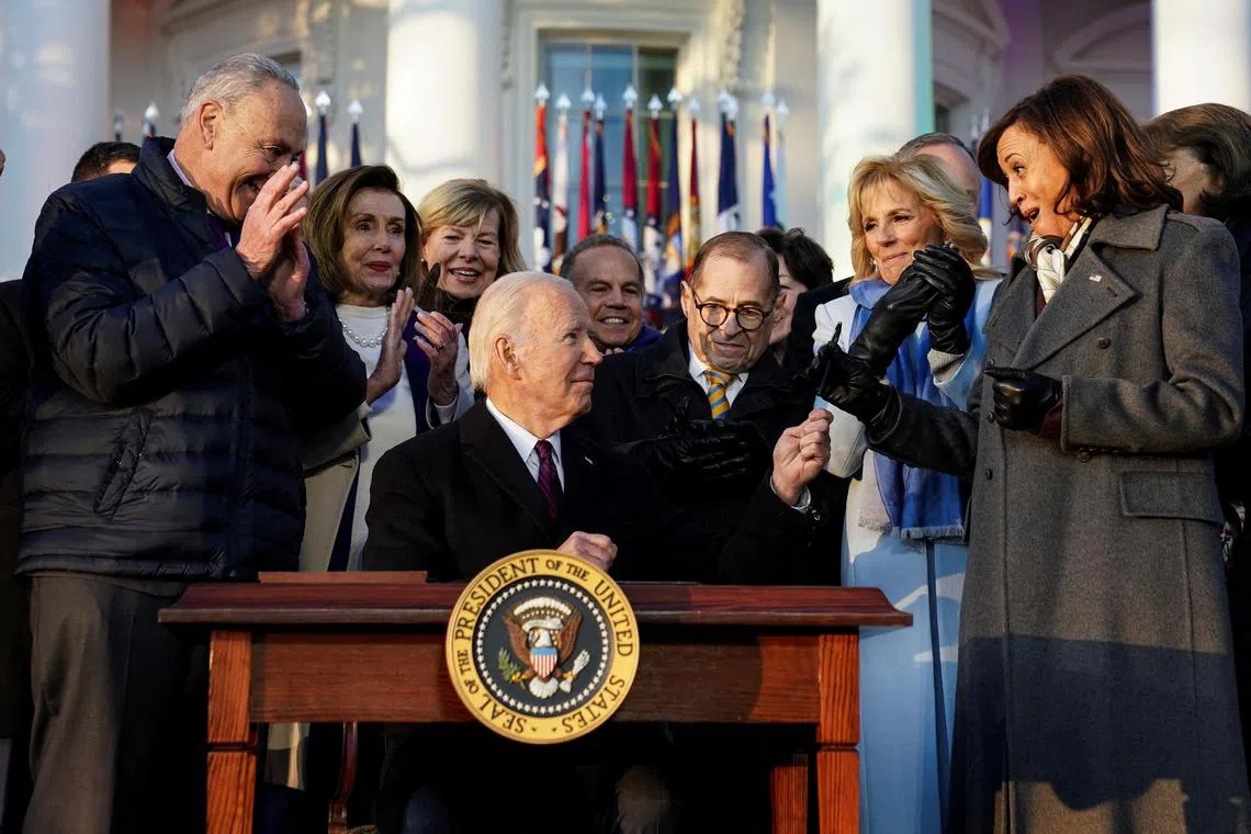 U.S. President Joe Biden holds up his pen to the cheers of the crowd, as well as U.S. Senator Cory Booker, Senate Majority Leader Chuck Schumer, House Speaker Nancy Pelosi, U.S. Senator Tammy Baldwin, Rep. Jerry Nadler, second gentleman Doug Emhoff, first lady Jill Biden, Vice President Kamala Harris and Senator Dianne Feinstein after signing the "Respect for Marriage Act," a landmark bill protecting same-sex marriage, on the South Lawn at the White House in Washington, U.S., December 13, 2022. REUTERS/Kevin Lamarque       TPX IMAGES OF THE DAY     