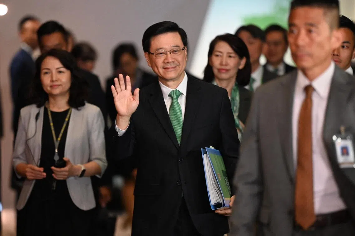 Hong Kong Chief Executive John Lee (C) waves to the media as he arrives at Central Government offices to deliver his annual policy address on October 25, 2023. (Photo by Peter PARKS / AFP)