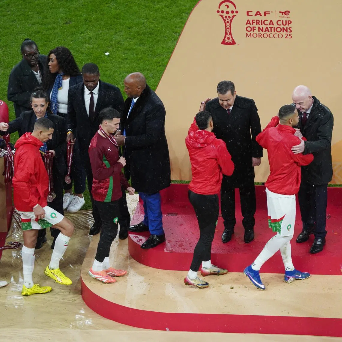 Soccer Football - CAF Africa Cup of Nations - Morocco 2025 - Final - Senegal v Morocco - Prince Moulay Abdellah Stadium, Rabat, Morocco - January 18, 2026 Morocco players are consoled on the stage by CAF president Patrice Motsepe and FIFA president Gianni Infantino as they collect their runners up medals REUTERS/Stringer
