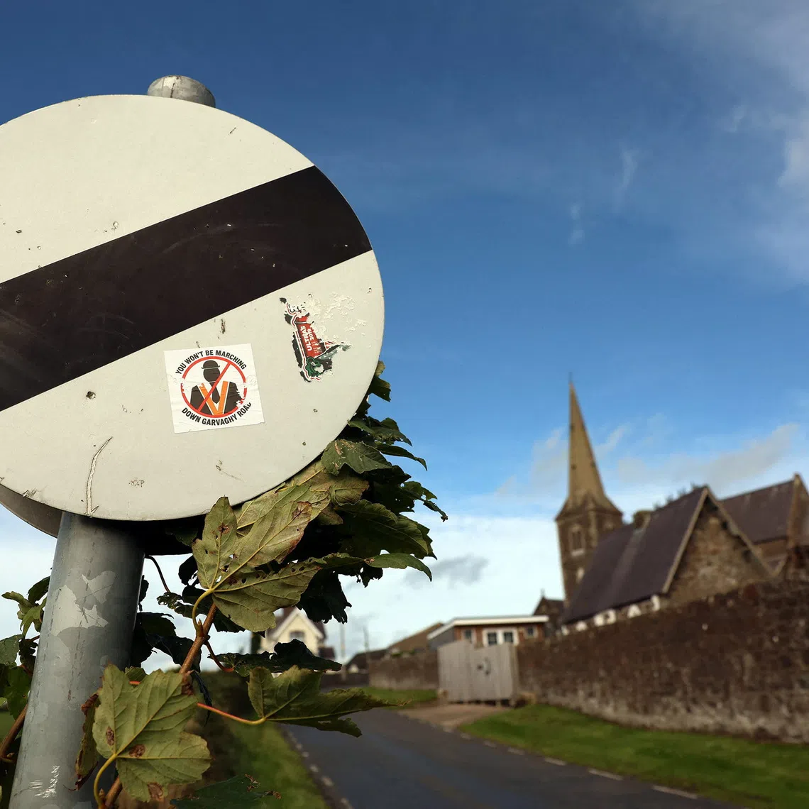 A road sign beside Drumcree Parish Church displays stickers opposing an Orange Order March, following the Parades Commissions ruling that the march can go ahead, in Portadown, Northern Ireland, September 25, 2026. REUTERS/Cathal McNaughton
