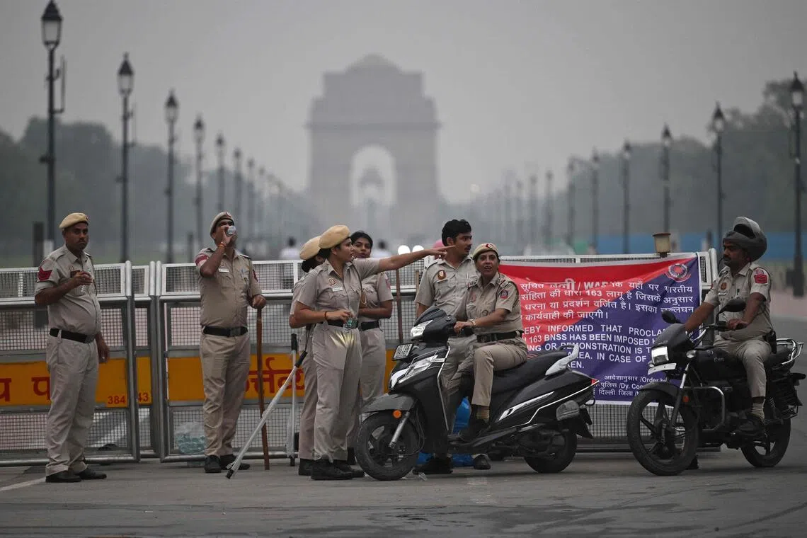 Delhi Police personnel stand guard near the India Gate in New Delhi on Oct 10, ahead of a protest by the youth-led Cockroach Janata Party.